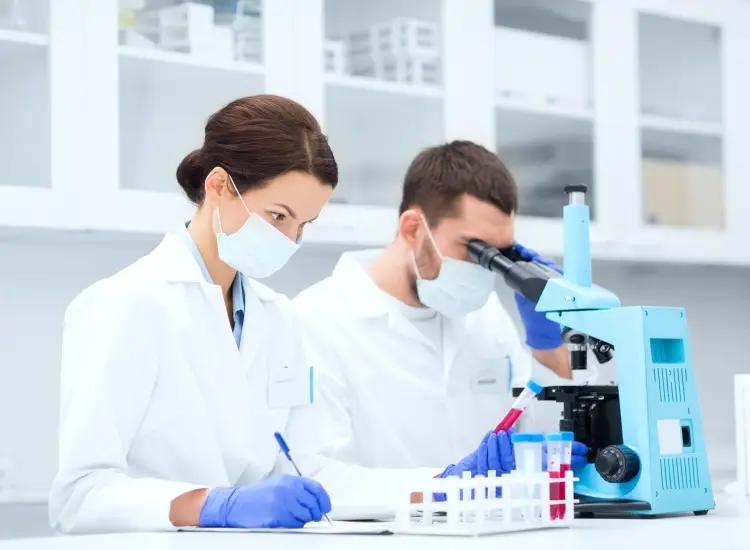 Profesionales de laboratorio analizando muestras al microscopio